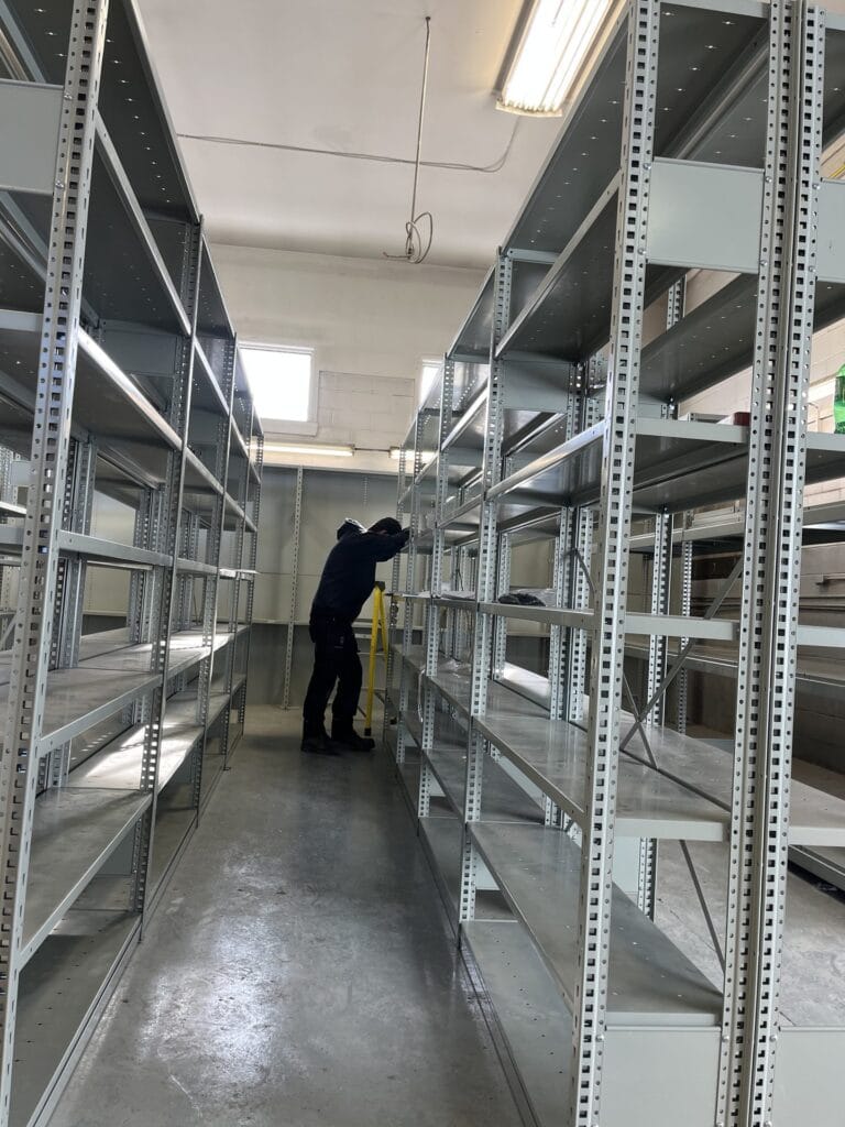 Technicien assemblant des rayonnages métalliques